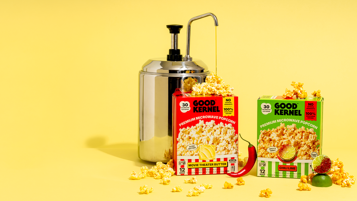Good Kernel Movie Theater Butter and Chili Lime microwave popcorn boxes next to a butter pump